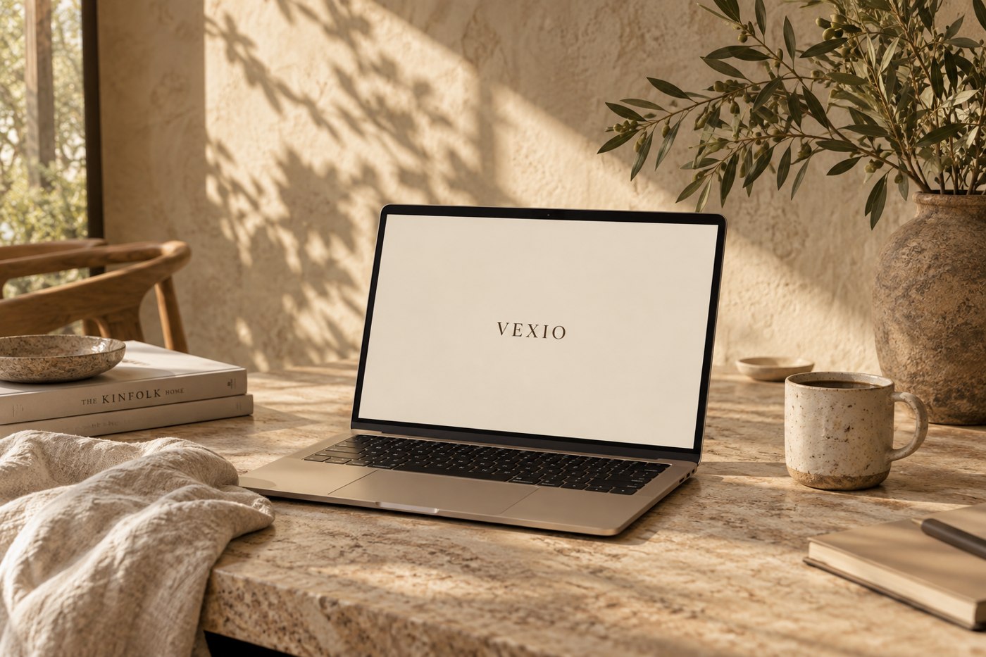 En ljus arbetsplats med laptop, keramik och gröna växter